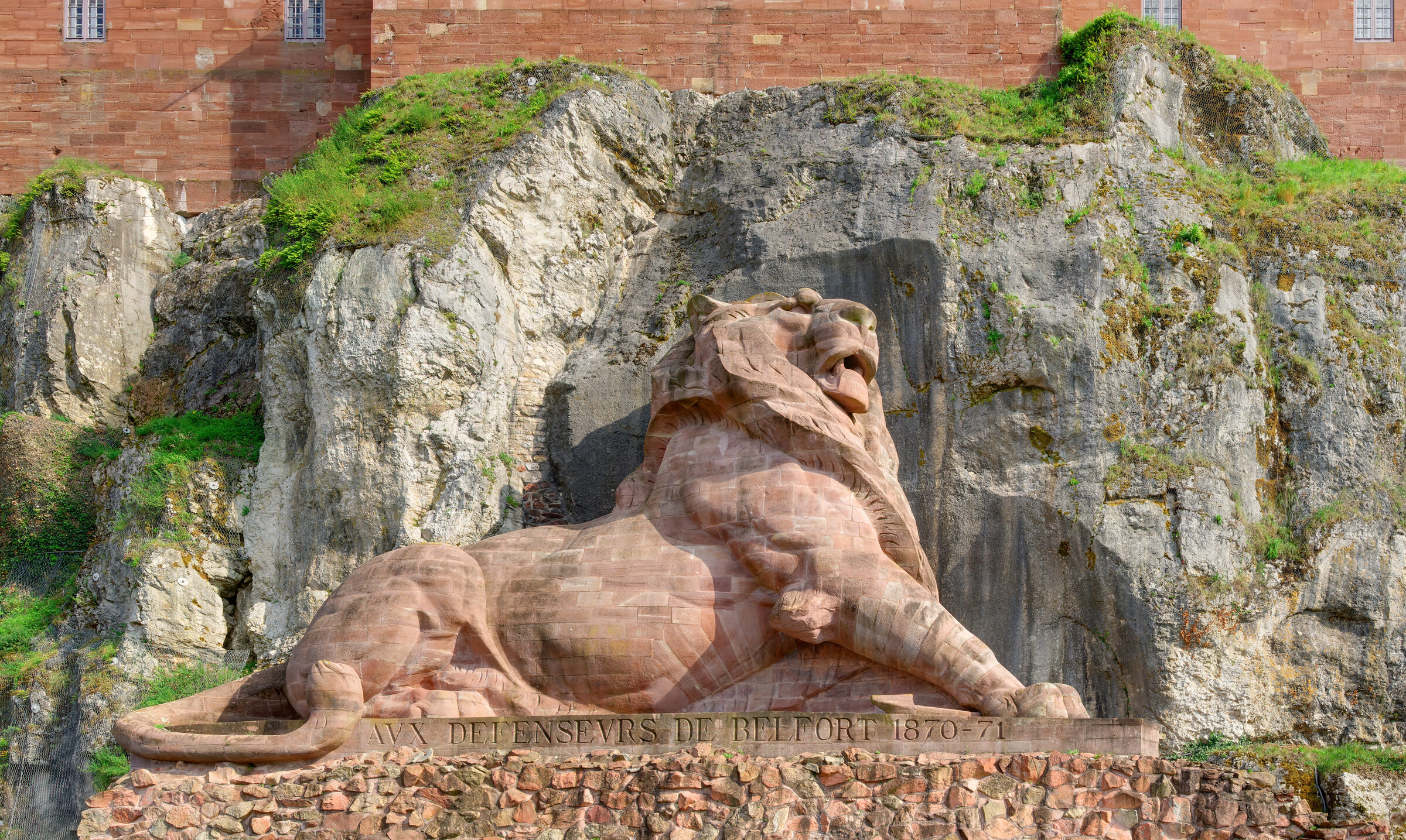 The Lion of Belfort carved in red sandstone, reclining against the rock of the citadel